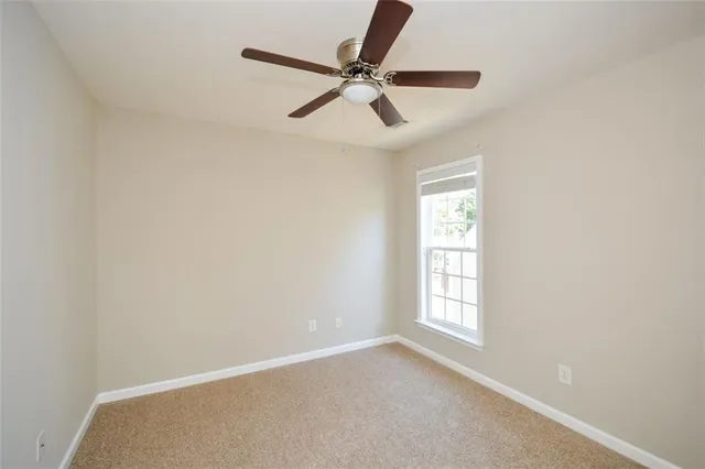 an empty room with chandelier fan
