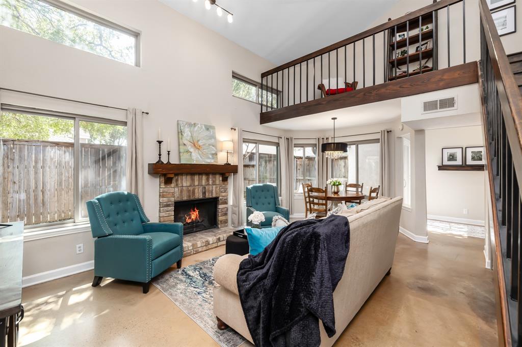 a living room with furniture a fireplace and a large window with garden view