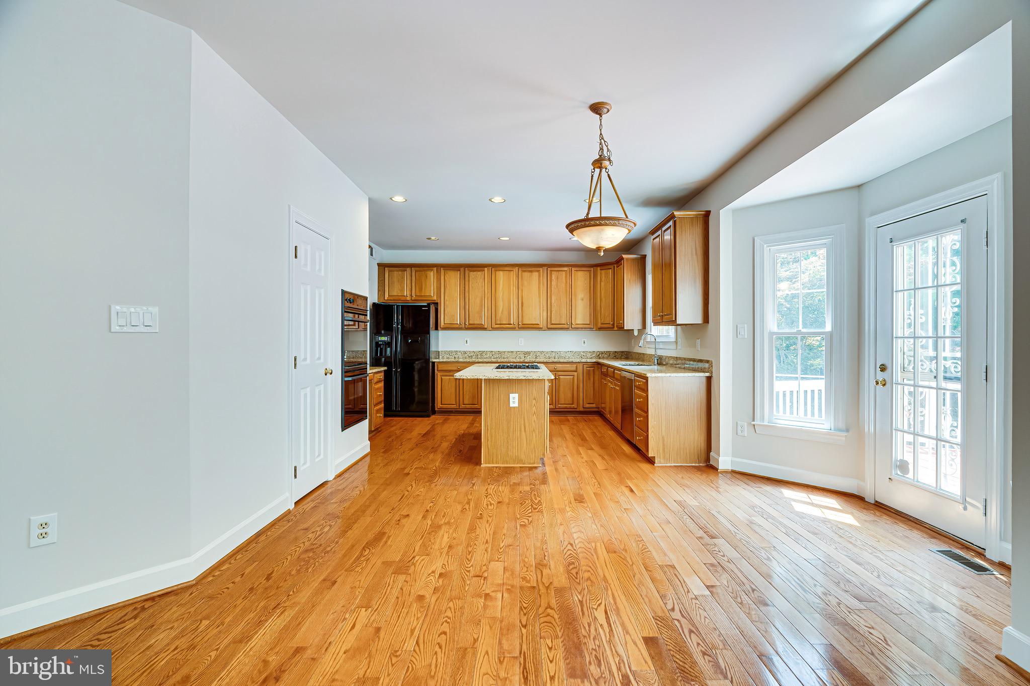 1936 Lord Fairfax Road Vienna, VA 22182 - Photo 25 of 81 a large kitchen with stainless steel appliances granite countertop a refrigerator and wooden floor