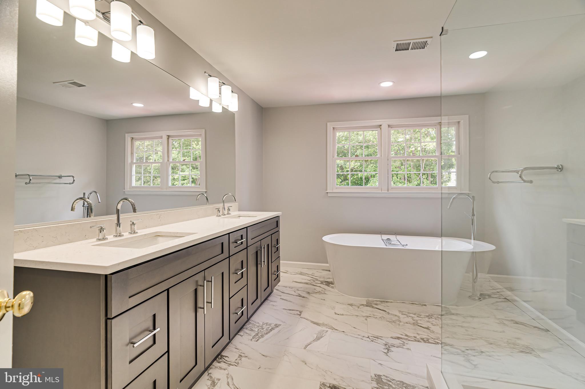 1936 Lord Fairfax Road Vienna, VA 22182 - Photo 42 of 81 a spacious bathroom with a double vanity sink a large mirror and a toilet a window