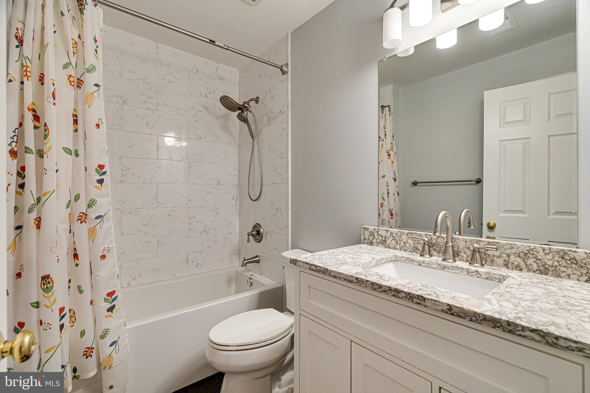 1936 Lord Fairfax Road Vienna, VA 22182 - Photo 52 of 81 a bathroom with a granite countertop sink a toilet and shower