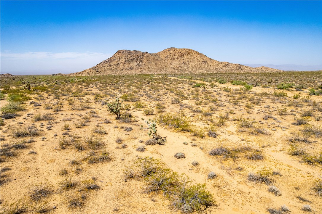 0 East Arroyo Road Yucca, AZ 86438 - Photo 25 of 25 Expansive desert landscape with scattered low-lying vegetation and a prominent rocky mountain range in the background