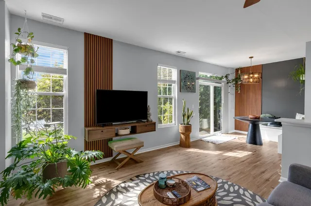 a view of a dining room with wooden floor and a chandelier