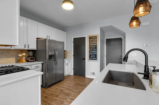 a kitchen with a refrigerator and a stove top oven