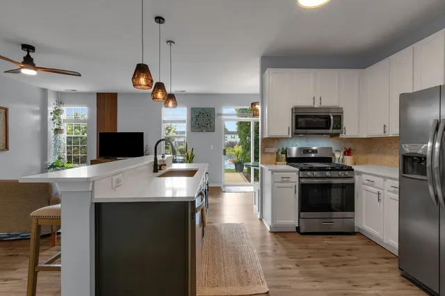 a kitchen with kitchen island a counter appliances a sink and a stove