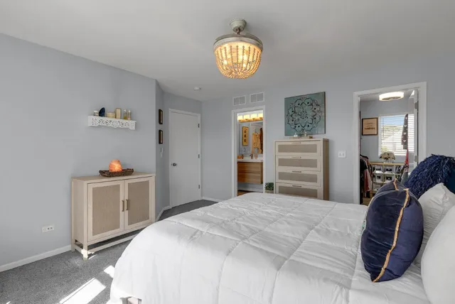 a bedroom with a bed and a chandelier