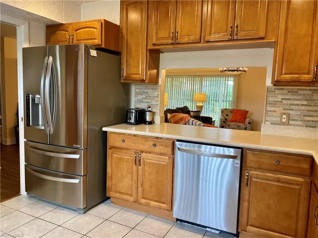 a kitchen with stainless steel appliances granite countertop a refrigerator and a sink