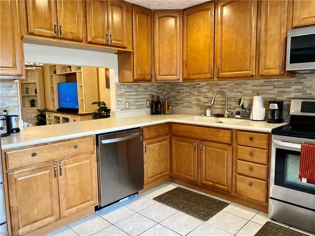 a kitchen with stainless steel appliances granite countertop a sink stove and cabinets