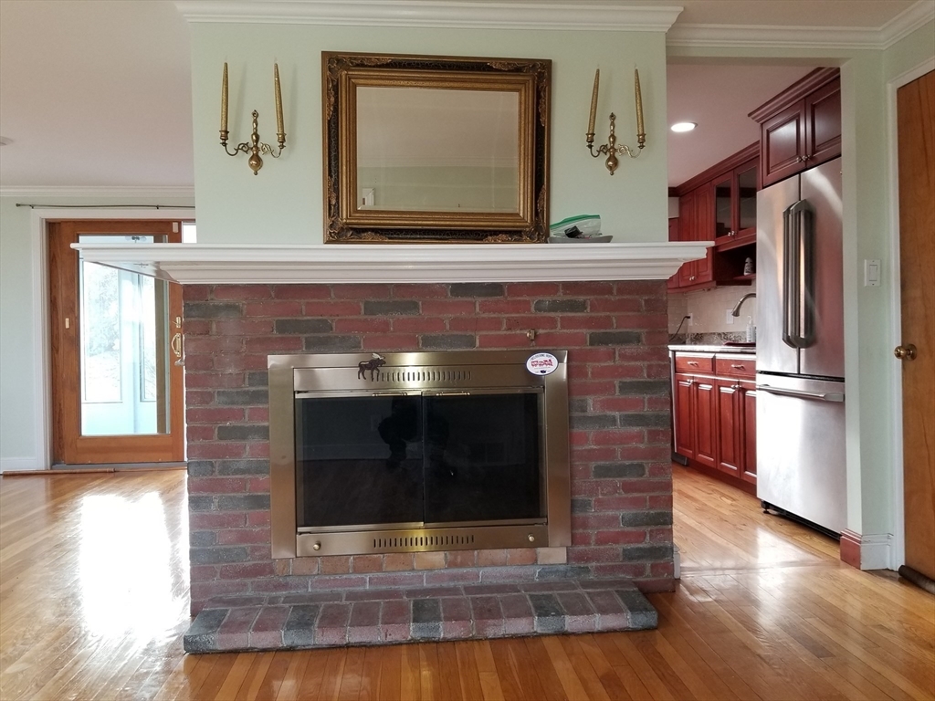 225 Governors Road, Unit 225 Quincy, MA 02169 - Photo 8 of 19 a kitchen with granite countertop a stove fireplace and a wooden floor