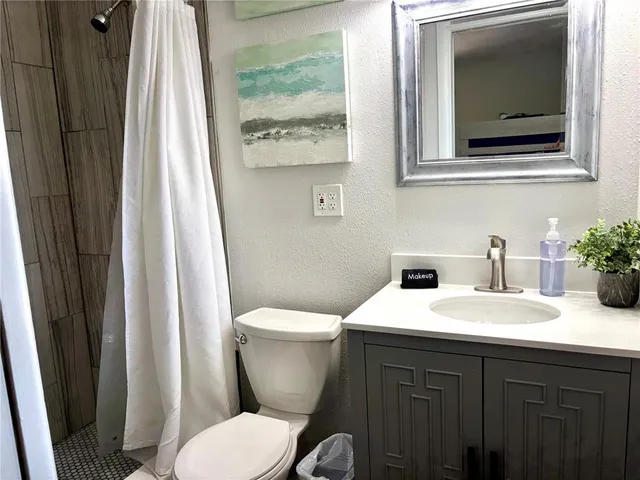 a bathroom with a toilet a sink and a mirror