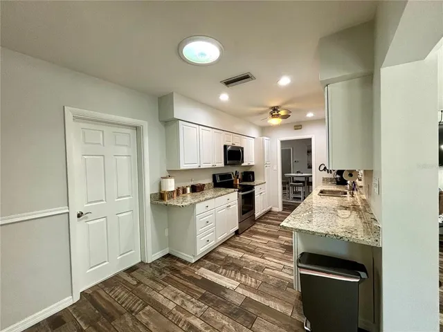 a large kitchen with kitchen island a sink stainless steel appliances and cabinets