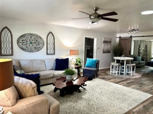 a living room with furniture a clock on wall and a table
