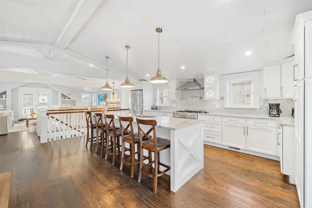a kitchen with stainless steel appliances kitchen island granite countertop a table chairs sink and cabinets