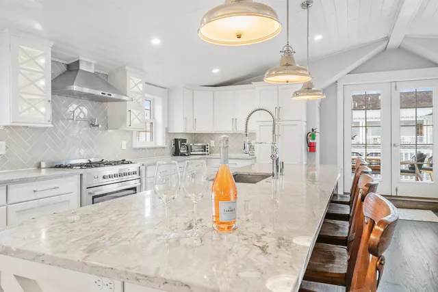 a kitchen with stainless steel appliances kitchen island granite countertop a stove and white cabinets