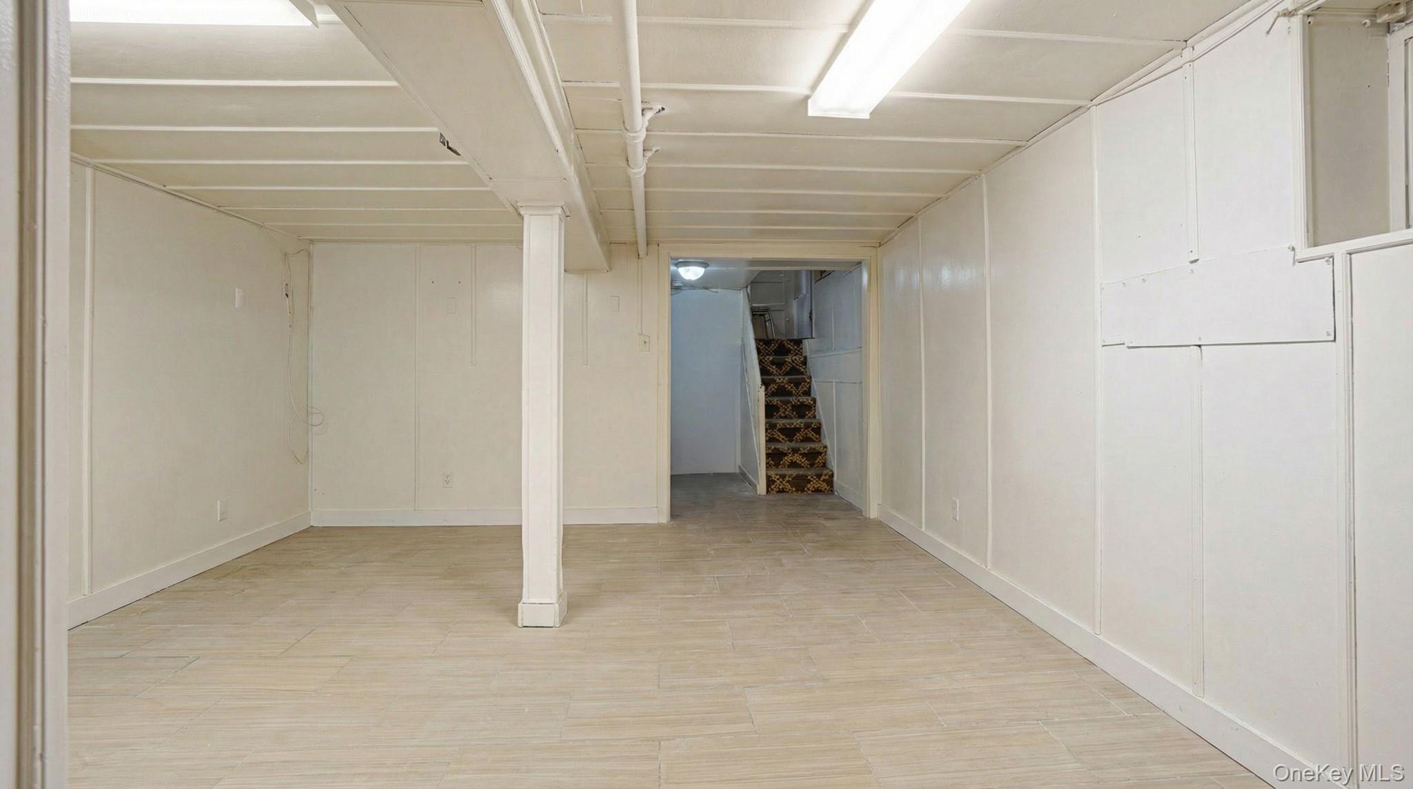 237-09 93rd Road Queens, NY 11426 - Photo 11 of 17 Finished below grade area featuring a decorative wall and light wood-style floors