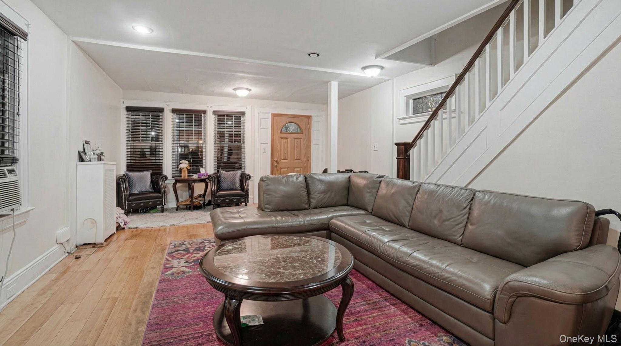 237-09 93rd Road Queens, NY 11426 - Photo 5 of 17 Living area featuring light wood finished floors, stairway, and recessed lighting