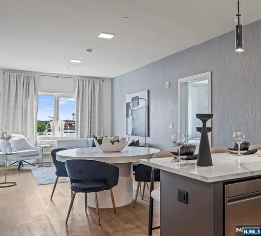 a view of a a dining room with furniture window and wooden floor