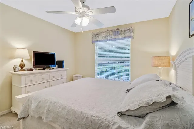 a bedroom with a bed a tv and wooden floor