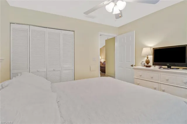 a bedroom with a flat screen tv and a chandelier