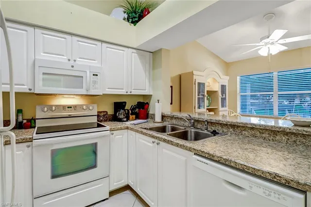 a kitchen with granite countertop a sink stainless steel appliances a counter space and cabinets