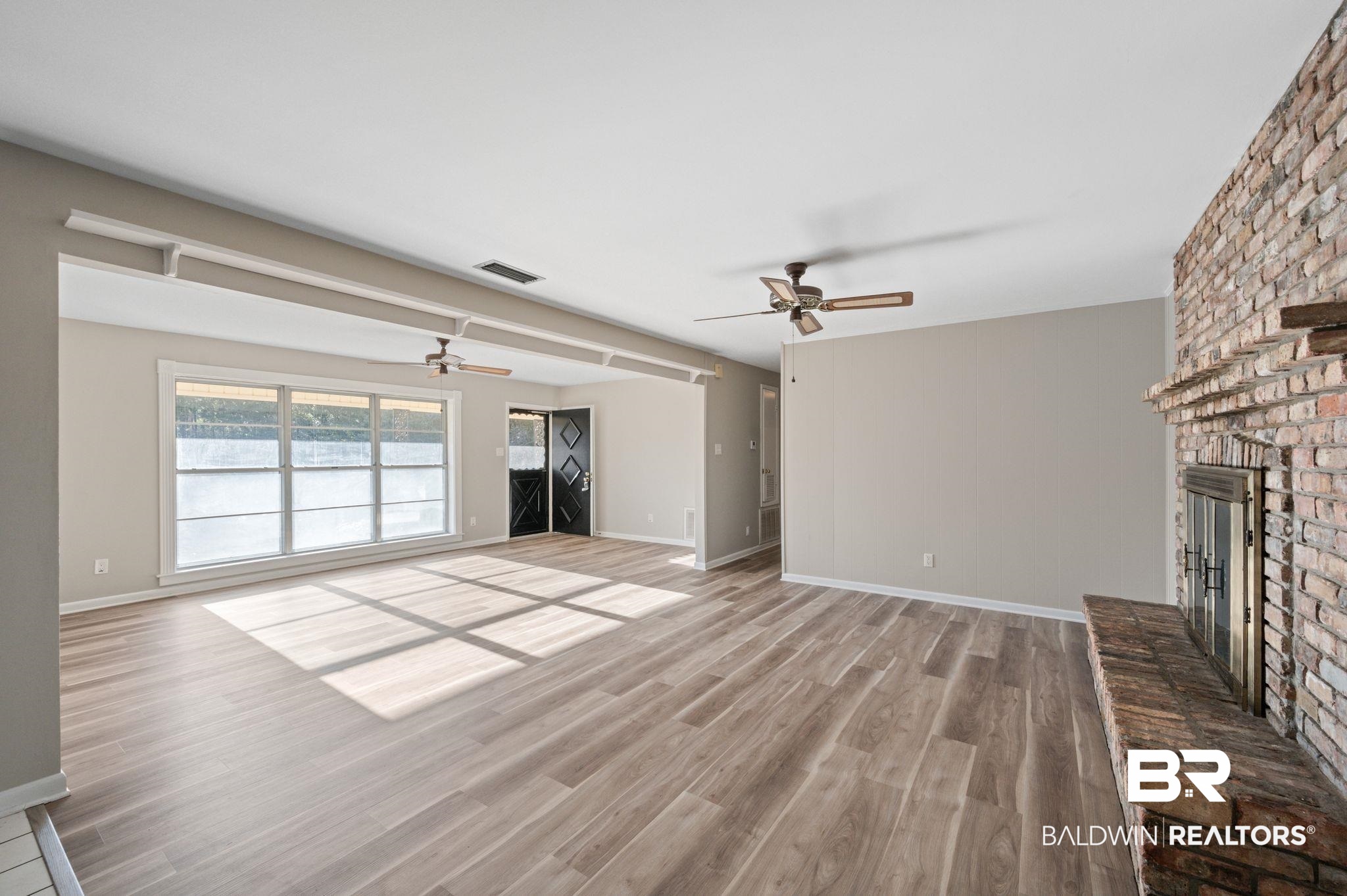 909 Caroline Avenue Daphne, AL 36526 - Photo 11 of 46 Unfurnished living room with a fireplace, light hardwood / wood-style flooring, and ceiling fan