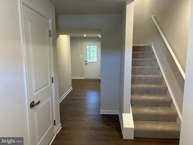 a view of a hallway with wooden floor and entryway