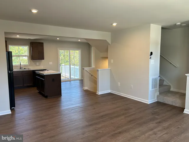 a view of a kitchen with cabinets and wooden floor