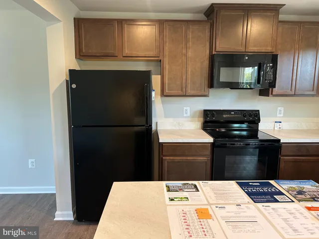 a kitchen with a refrigerator and a stove top oven