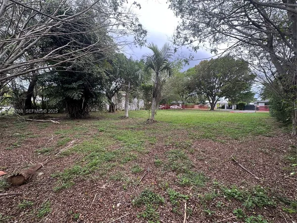a view of a field with trees in the background