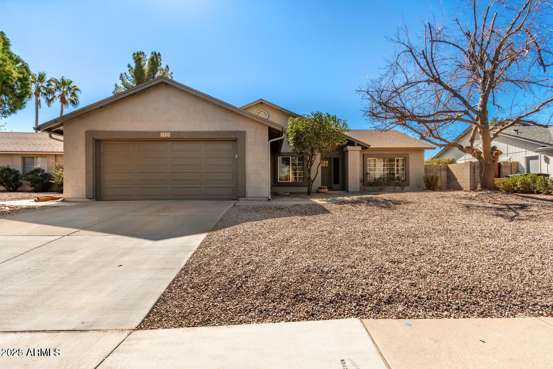 2221 West Rockwell Drive Chandler, AZ 85224 - Photo 1 of 14 a front view of a house with a yard and garage