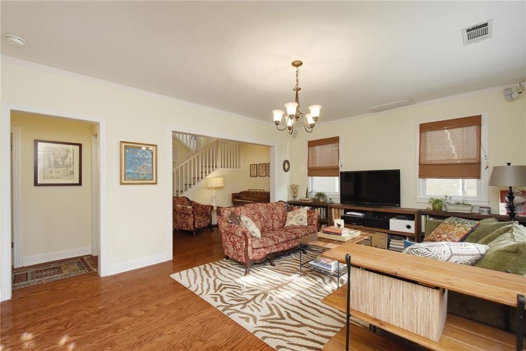 4412 Barrow Avenue, Unit A Austin, TX 78751 - Photo 3 of 28 Living room with wood finished floors, ornamental molding, a chandelier, and stairs