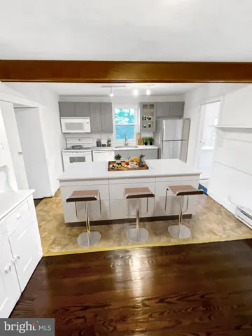 a living room with stainless steel appliances kitchen island granite countertop a sink and a stove