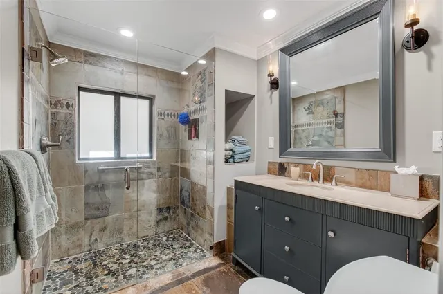 a bathroom with a sink toilet a mirror and shower