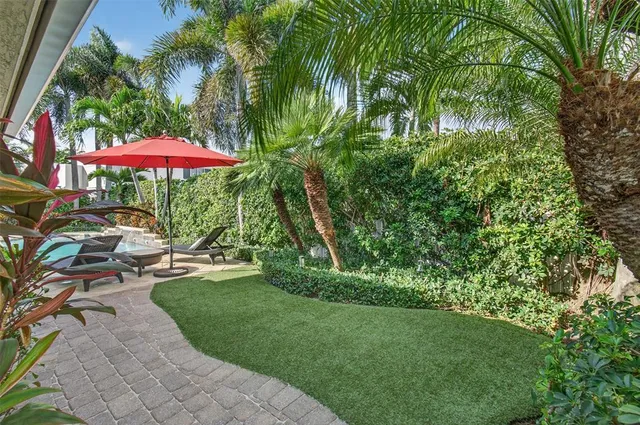 a view of a patio with chairs and a table under an umbrella
