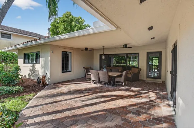 a view of a patio with table and chairs and floor to ceiling window
