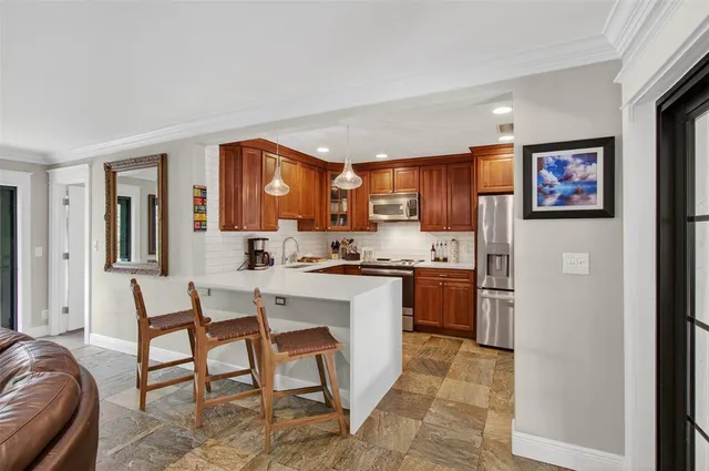 a kitchen with stainless steel appliances granite countertop a refrigerator and a stove top oven