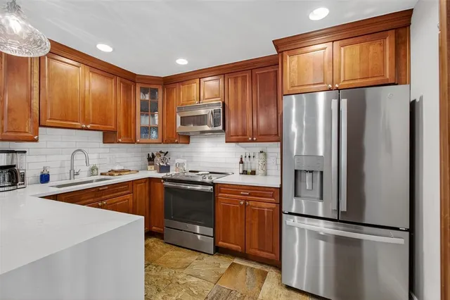 a kitchen with stainless steel appliances granite countertop a refrigerator sink and cabinets