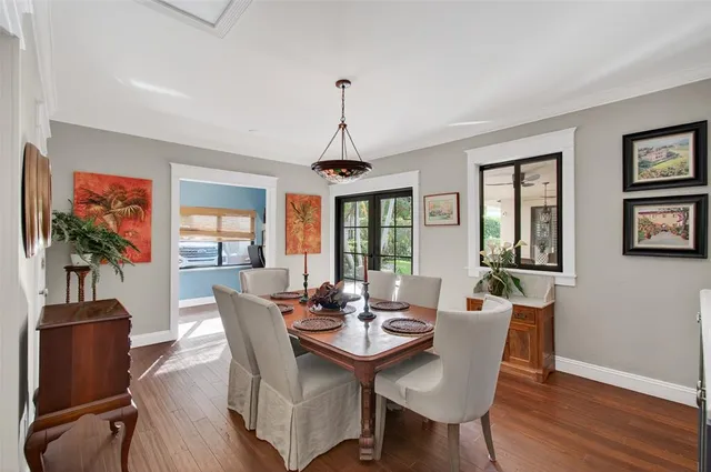 a dining room with furniture a chandelier and wooden floor