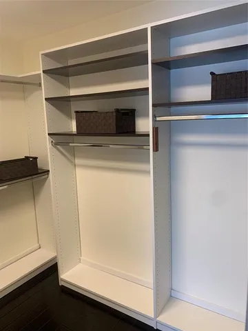 a view of walk in closet with empty racks