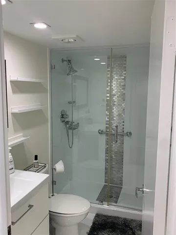 a bathroom with a sink a toilet and shower