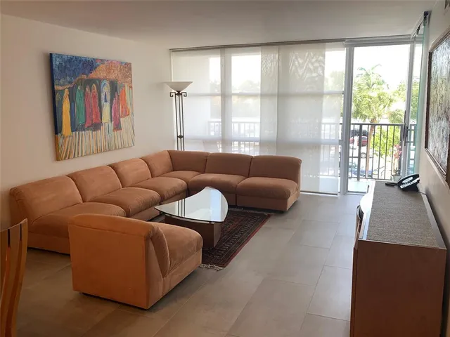 a living room with furniture and a floor to ceiling window
