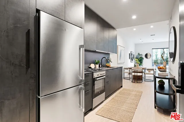 a kitchen with stainless steel appliances granite countertop a refrigerator and a stove top oven