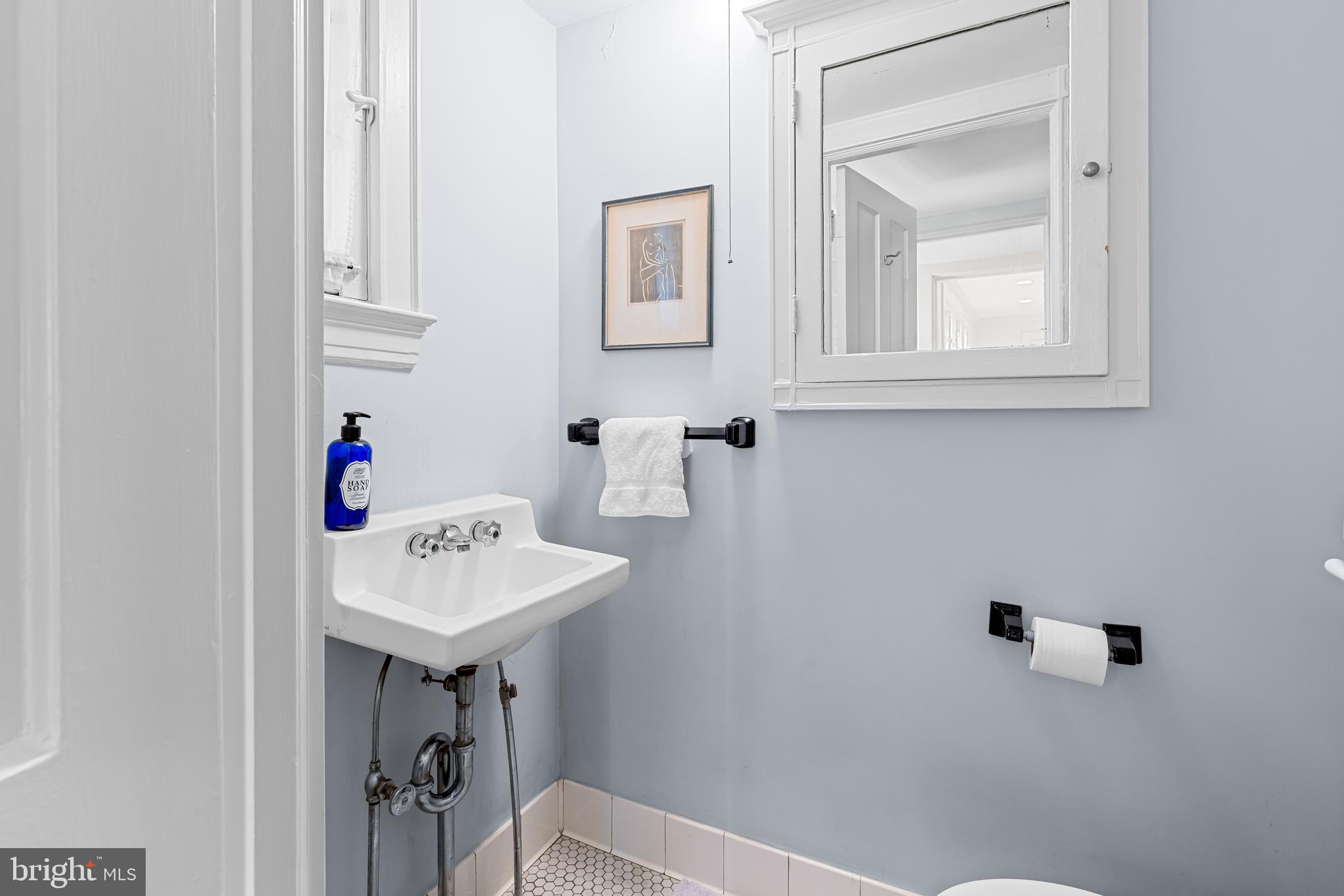 308 Northfield Place Baltimore, MD 21210 - Photo 15 of 41 a bathroom with a sink a mirror and a toilet