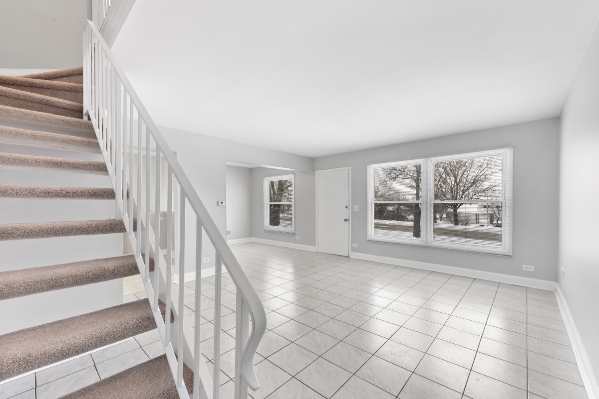 1681 Queensbury Circle Hoffman Estates, IL 60169 - Photo 3 of 13 a view of an empty room with wooden floor and a large window