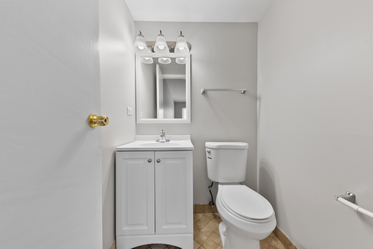 1681 Queensbury Circle Hoffman Estates, IL 60169 - Photo 9 of 13 a bathroom with a toilet sink and mirror