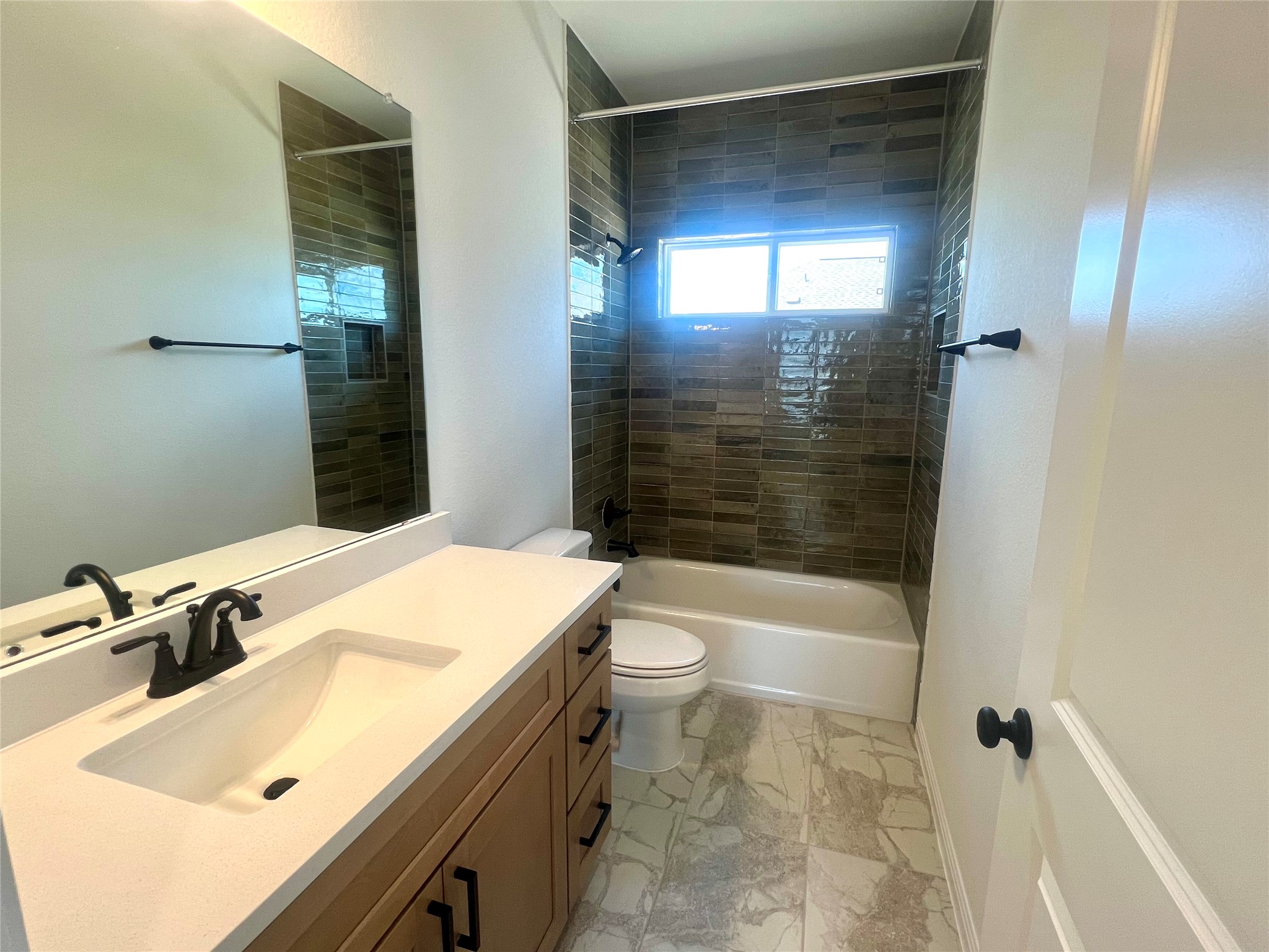 365 Young Street Buda, TX 78610 - Photo 17 of 27 a bathroom with a sink a toilet and shower