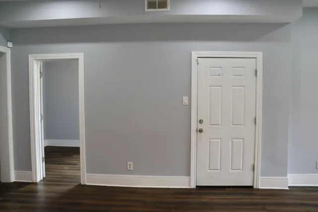 a view of empty room with wooden floor
