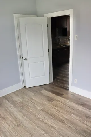 a bedroom with a bed and a lamp on dresser