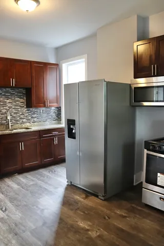 a view of kitchen with granite countertop a sink and cabinets