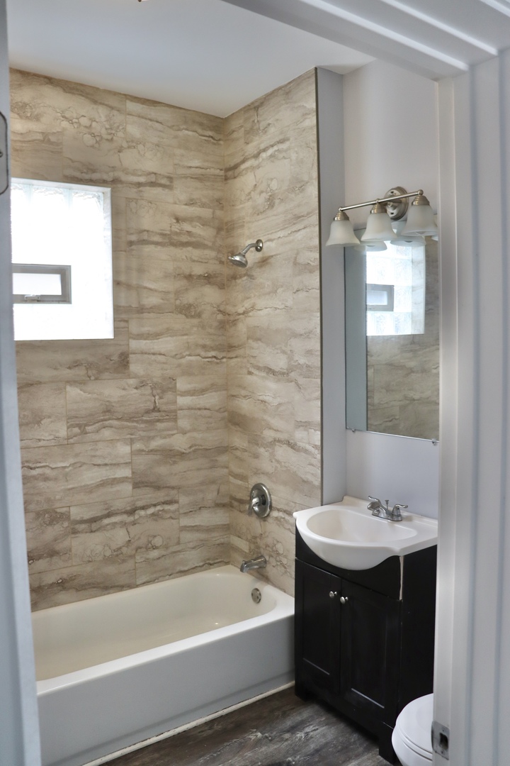 5718 South Sangamon Street, Unit 2 Chicago, IL 60621 - Photo 29 of 35 a bathroom with a tub a sink and mirror